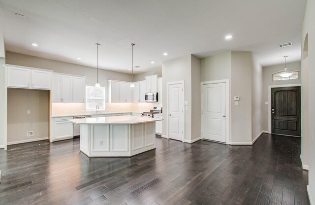 6914 N Elmwood Trl, Katy, TX 77493 - kitchen featuring stainless steel appliances, a center island, dark wood-type flooring, tasteful backsplash, and recessed lighting