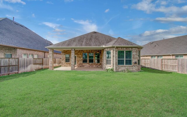 6914 N Elmwood Trl, Katy, TX 77493 - rear view of house with a fenced backyard, a patio area, brick siding, and roof with shingles