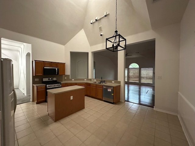 2606 Iris Ct, Pearland, TX 77584 - kitchen with appliances with stainless steel finishes, light countertops, high vaulted ceiling, a center island, and light tile patterned floors