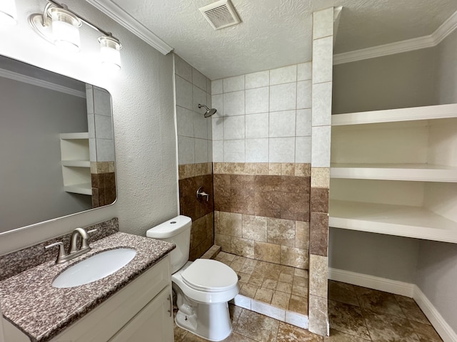 1013 E 40th St, Houston, TX 77022 - bathroom featuring a tile shower, vanity, ornamental molding, stone tile flooring, and a textured ceiling
