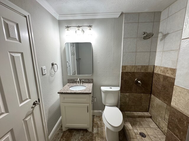 1013 E 40th St, Houston, TX 77022 - full bathroom featuring tiled shower, ornamental molding, vanity, a textured wall, and a textured ceiling