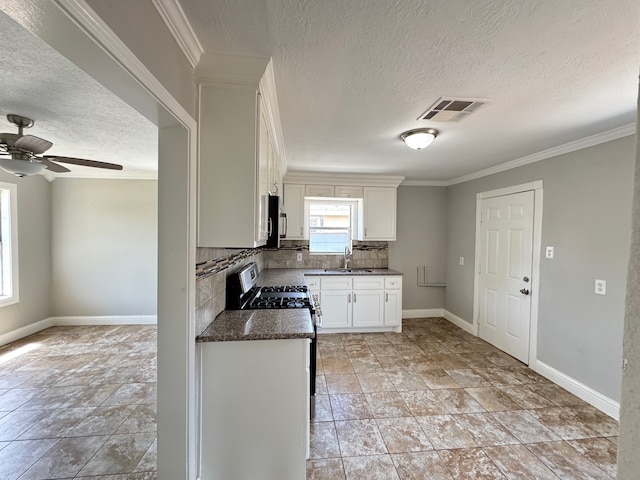 1013 E 40th St, Houston, TX 77022 - kitchen featuring a textured ceiling, decorative backsplash, ceiling fan, white cabinets, and crown molding