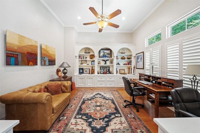 7417 Teaswood Dr, Conroe, TX 77304 - home office with a ceiling fan, light wood finished floors, crown molding, a towering ceiling, and recessed lighting