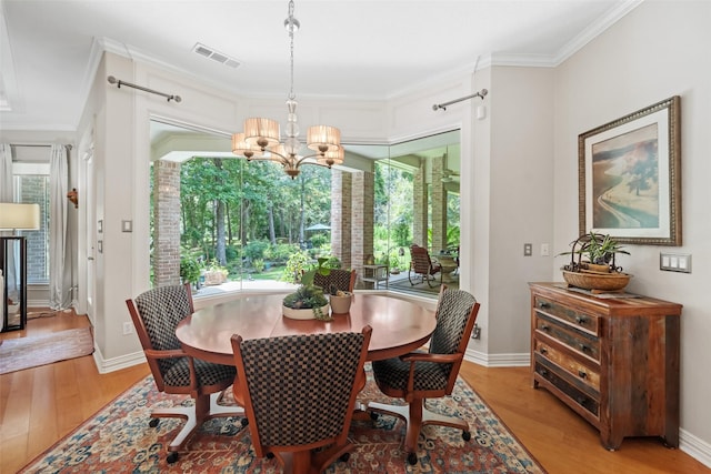 7417 Teaswood Dr, Conroe, TX 77304 - dining area featuring ornamental molding, a chandelier, healthy amount of natural light, and light wood finished floors
