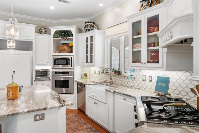 7417 Teaswood Dr, Conroe, TX 77304 - kitchen featuring appliances with stainless steel finishes, white cabinetry, decorative light fixtures, ornamental molding, and recessed lighting
