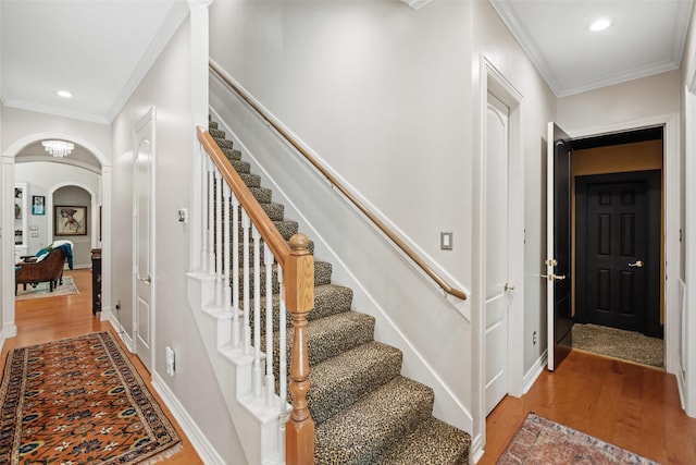 7417 Teaswood Dr, Conroe, TX 77304 - staircase with wood finished floors, arched walkways, ornamental molding, and recessed lighting