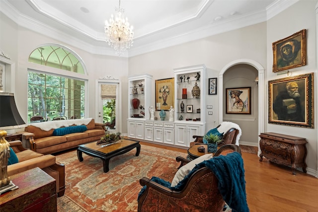 7417 Teaswood Dr, Conroe, TX 77304 - living room with a chandelier, light wood-type flooring, crown molding, a raised ceiling, and a towering ceiling