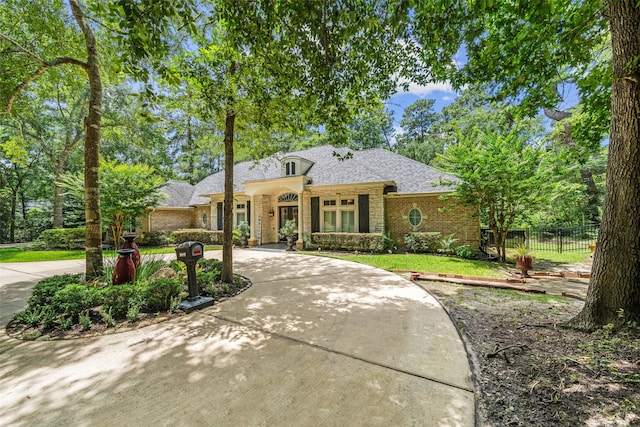 7417 Teaswood Dr, Conroe, TX 77304 - view of front of house featuring brick siding, curved driveway, and roof with shingles