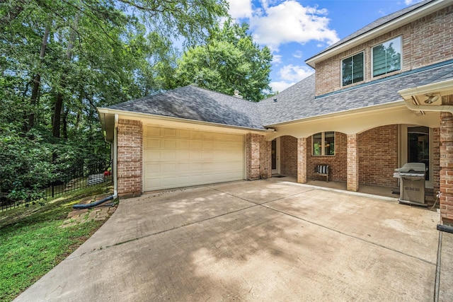 7417 Teaswood Dr, Conroe, TX 77304 - view of front of house featuring roof with shingles, concrete driveway, a garage, and brick siding