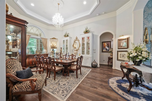 7417 Teaswood Dr, Conroe, TX 77304 - dining space featuring a chandelier, arched walkways, crown molding, dark wood-style flooring, and a raised ceiling