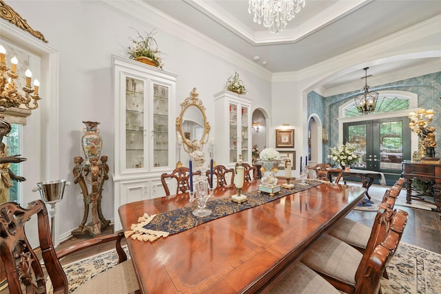 7417 Teaswood Dr, Conroe, TX 77304 - dining area with a chandelier, french doors, wood finished floors, arched walkways, and ornamental molding