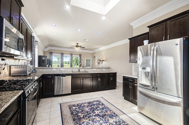 907 Fairway Dr, La Porte, TX 77571 - kitchen with appliances with stainless steel finishes, ceiling fan, light stone counters, a peninsula, and recessed lighting