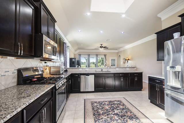 907 Fairway Dr, La Porte, TX 77571 - kitchen featuring appliances with stainless steel finishes, light tile patterned flooring, decorative backsplash, light stone countertops, and ornamental molding
