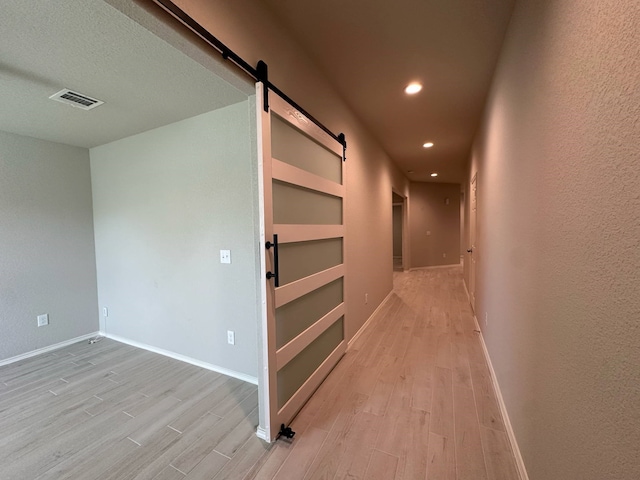 4215 Stuebner Hill Dr, Houston, TX 77068 - hallway featuring a barn door, light wood-style floors, recessed lighting, and built in features