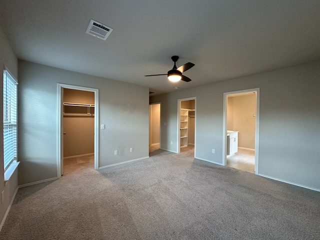 4215 Stuebner Hill Dr, Houston, TX 77068 - unfurnished bedroom with a spacious closet, light carpet, connected bathroom, a ceiling fan, and a closet