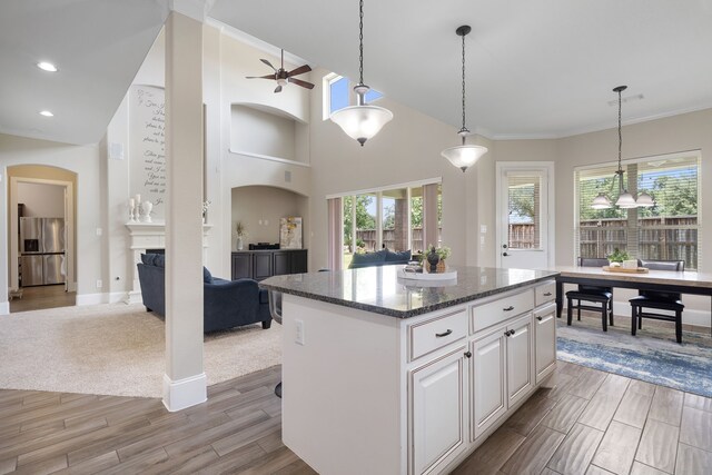 19522 Hope Springs Ln, Cypress, TX 77433 - kitchen featuring stainless steel fridge, open floor plan, a ceiling fan, light wood-type flooring, and a center island