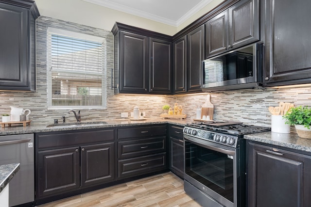 19522 Hope Springs Ln, Cypress, TX 77433 - kitchen with stainless steel appliances, ornamental molding, stone counters, tasteful backsplash, and light wood finished floors