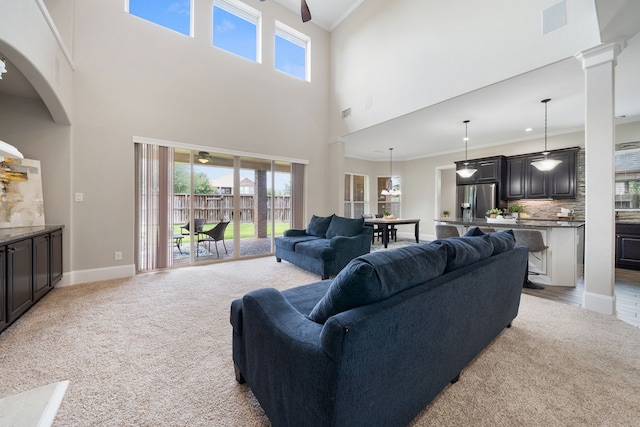 19522 Hope Springs Ln, Cypress, TX 77433 - living room with ceiling fan, light carpet, a high ceiling, ornamental molding, and arched walkways