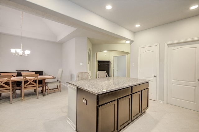 115 Meadow Ridge Way, Clute, TX 77531 - kitchen featuring light tile patterned floors, arched walkways, light stone counters, a center island, and pendant lighting