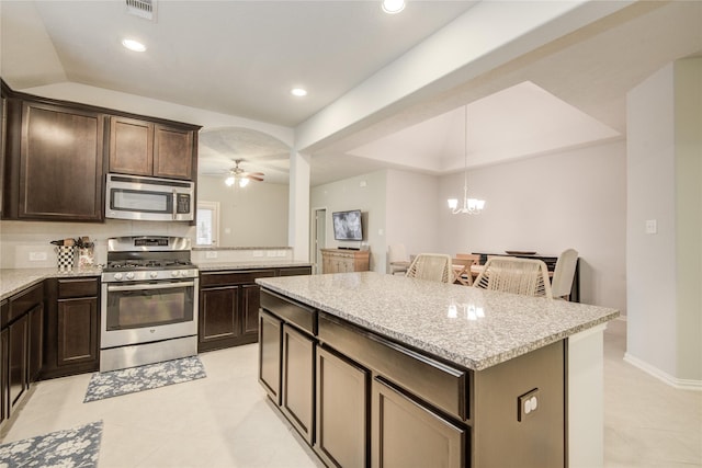 115 Meadow Ridge Way, Clute, TX 77531 - kitchen with appliances with stainless steel finishes, dark brown cabinets, light tile patterned flooring, ceiling fan, and recessed lighting