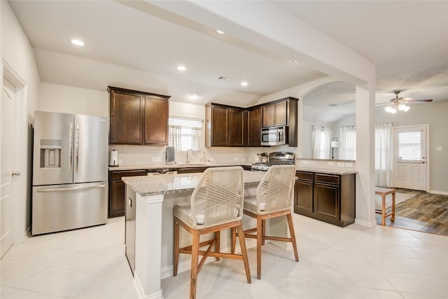 115 Meadow Ridge Way, Clute, TX 77531 - kitchen featuring stainless steel appliances, dark brown cabinets, healthy amount of natural light, ceiling fan, and lofted ceiling