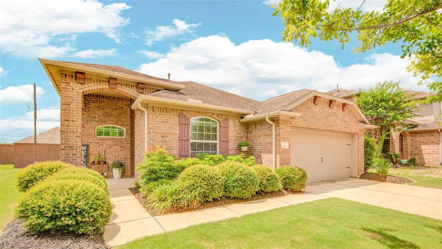 115 Meadow Ridge Way, Clute, TX 77531 - view of front of property with brick siding, driveway, an attached garage, and a shingled roof