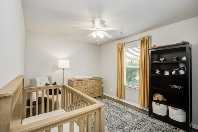 115 Meadow Ridge Way, Clute, TX 77531 - bedroom featuring wood finished floors, a crib, and ceiling fan
