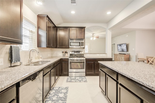 115 Meadow Ridge Way, Clute, TX 77531 - kitchen with stainless steel appliances, dark brown cabinetry, a ceiling fan, decorative backsplash, and recessed lighting