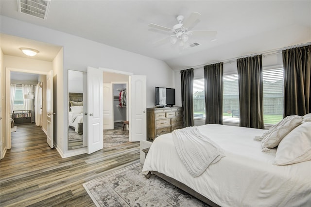 115 Meadow Ridge Way, Clute, TX 77531 - bedroom featuring wood finished floors, multiple windows, vaulted ceiling, a walk in closet, and ceiling fan