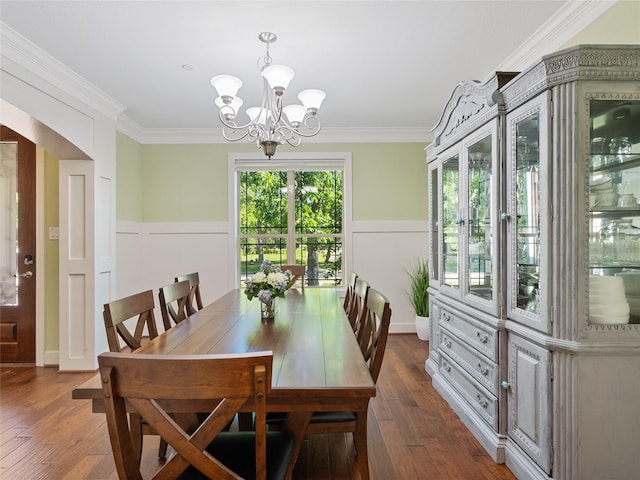 4635 Beech St, Bellaire, TX 77401 - dining space featuring a chandelier, a wainscoted wall, dark wood-type flooring, ornamental molding, and arched walkways