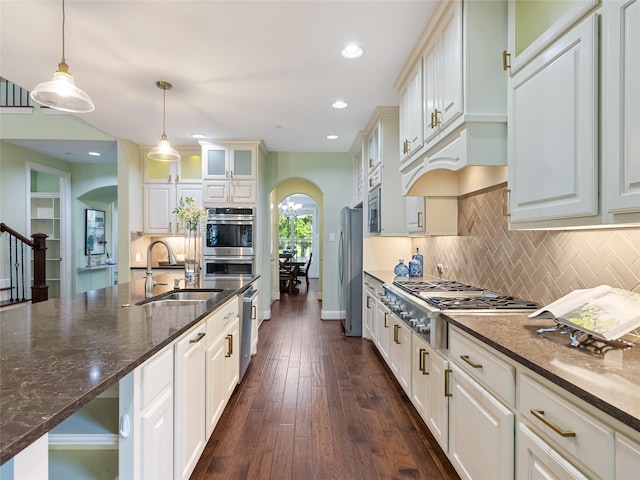 4635 Beech St, Bellaire, TX 77401 - kitchen featuring arched walkways, stainless steel appliances, pendant lighting, backsplash, and recessed lighting