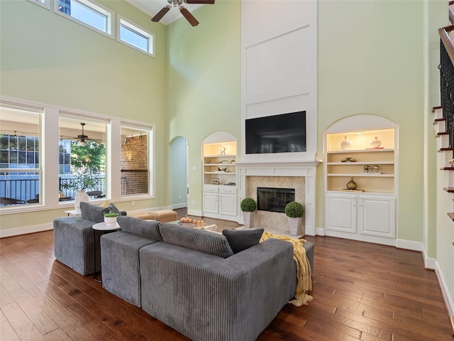 4635 Beech St, Bellaire, TX 77401 - living area with ceiling fan, a high ceiling, dark wood-type flooring, a fireplace with flush hearth, and built in shelves