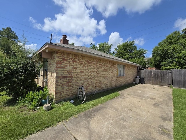 3902 Quiet Place Dr, Houston, TX 77082 - view of home's exterior with brick siding, a chimney, and a patio