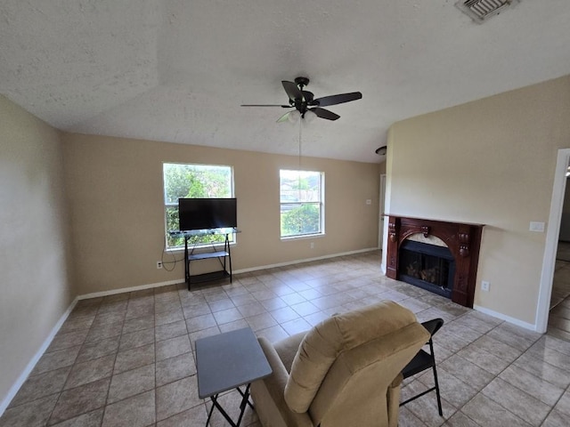 3902 Quiet Place Dr, Houston, TX 77082 - living area featuring a ceiling fan, a fireplace, a textured ceiling, and light tile patterned floors