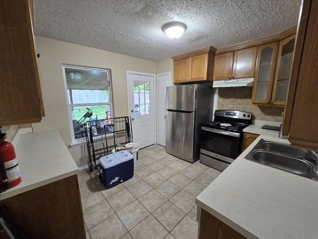 3902 Quiet Place Dr, Houston, TX 77082 - kitchen featuring stainless steel appliances, under cabinet range hood, glass insert cabinets, light countertops, and a textured ceiling