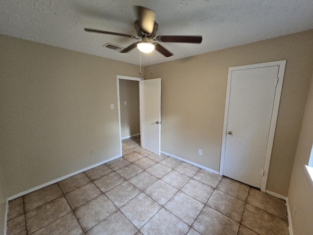 3902 Quiet Place Dr, Houston, TX 77082 - unfurnished bedroom with light tile patterned floors, a ceiling fan, and a textured ceiling