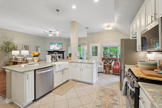 1095 Gladstone Dr, League City, TX 77573 - kitchen with appliances with stainless steel finishes, open floor plan, white cabinetry, light tile patterned floors, and lofted ceiling