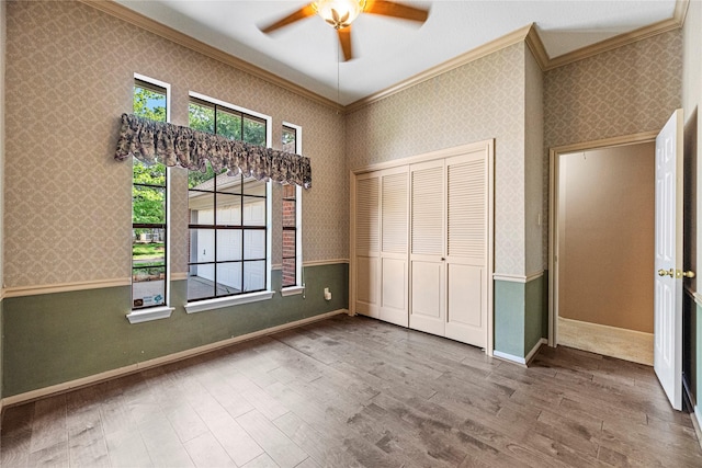 16307 Rainbow Lake Rd, Houston, TX 77095 - unfurnished bedroom with crown molding, wood finished floors, wallpapered walls, a closet, and ceiling fan