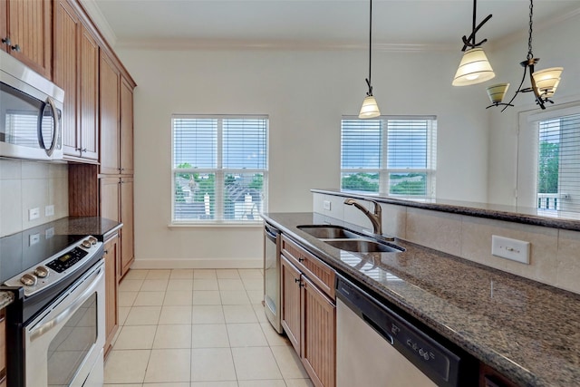 2203 Dorrington St Unit 406, Houston, TX 77030 - kitchen with stainless steel appliances, brown cabinets, decorative backsplash, crown molding, and decorative light fixtures