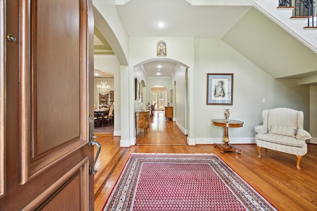 8518 Prichett Dr, Houston, TX 77096 - entrance foyer featuring light wood-type flooring, arched walkways, a chandelier, and stairway