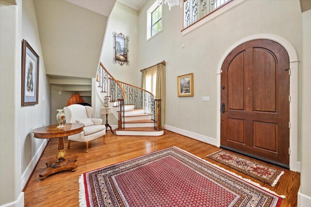 8518 Prichett Dr, Houston, TX 77096 - foyer featuring wood finished floors, stairway, arched walkways, and a towering ceiling