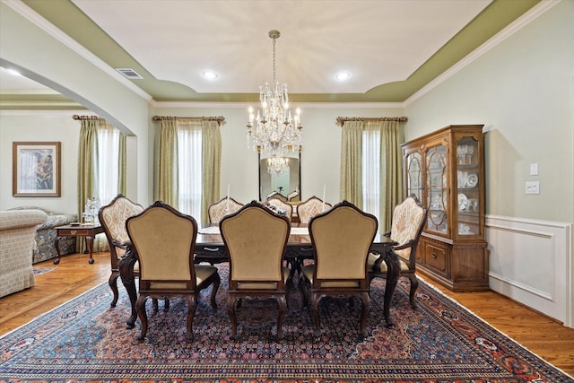 8518 Prichett Dr, Houston, TX 77096 - dining space featuring a chandelier, arched walkways, wood finished floors, ornamental molding, and wainscoting