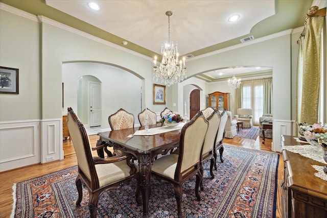 8518 Prichett Dr, Houston, TX 77096 - dining room with arched walkways, light wood-style flooring, a chandelier, wainscoting, and a decorative wall