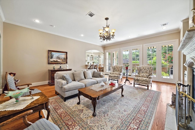 8518 Prichett Dr, Houston, TX 77096 - living area featuring arched walkways, a premium fireplace, crown molding, a chandelier, and light wood-type flooring