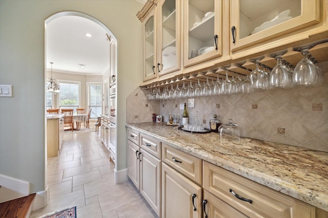 8518 Prichett Dr, Houston, TX 77096 - indoor dry bar featuring decorative backsplash, crown molding, and arched walkways