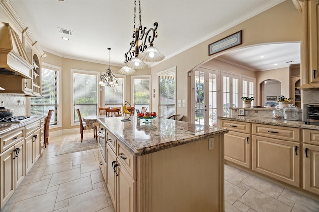 8518 Prichett Dr, Houston, TX 77096 - kitchen featuring arched walkways, decorative backsplash, a chandelier, a center island, and light stone counters