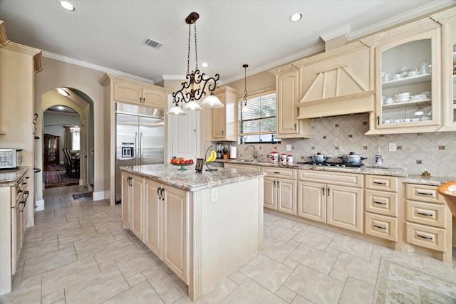 8518 Prichett Dr, Houston, TX 77096 - kitchen featuring appliances with stainless steel finishes, arched walkways, an island with sink, backsplash, and light stone counters