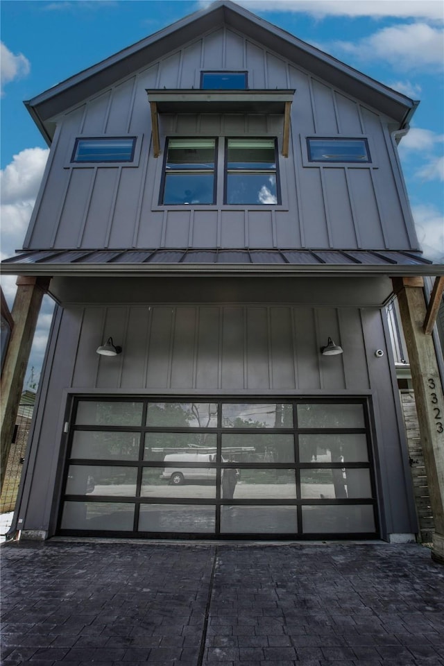 3323 Cornell St, Houston, TX 77022 - contemporary home featuring board and batten siding, decorative driveway, and a standing seam roof