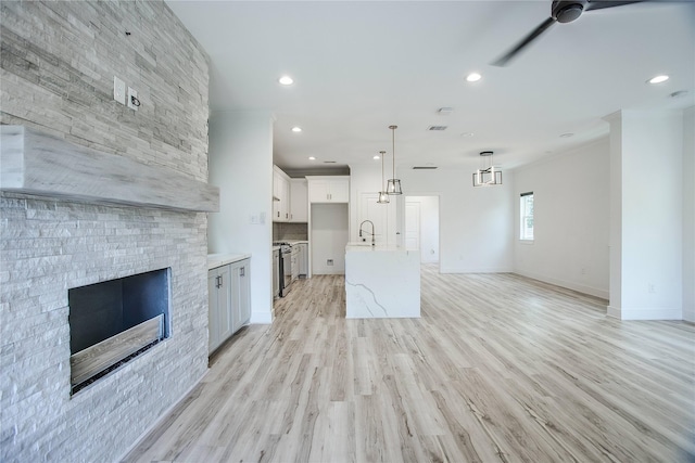 3323 Cornell St, Houston, TX 77022 - unfurnished living room with ceiling fan, a fireplace, recessed lighting, and light wood-style flooring
