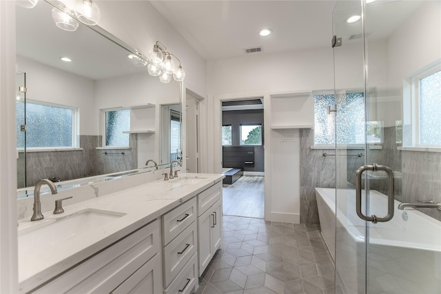 3323 Cornell St, Houston, TX 77022 - bathroom with a bathtub, double vanity, tile patterned floors, a stall shower, and recessed lighting
